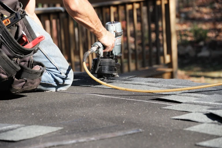 roofer nailing new shingles onto a roof in Austin, MN