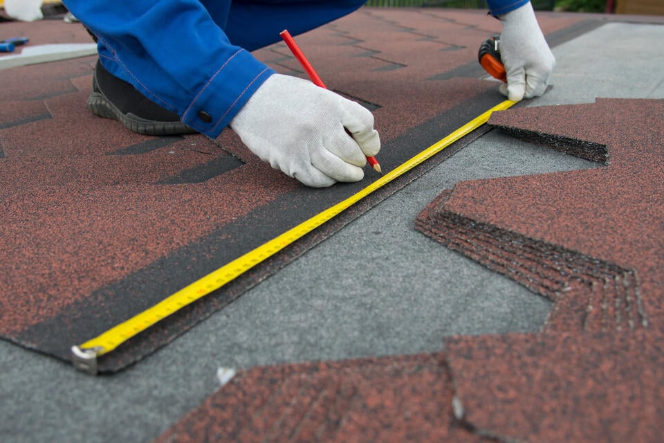 how to measure a roof for shingles-close up of tech measuring roofing shingles