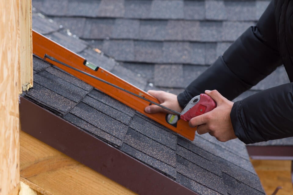 how to measure a roof for shingles-man using level and tape measure to measure roof
