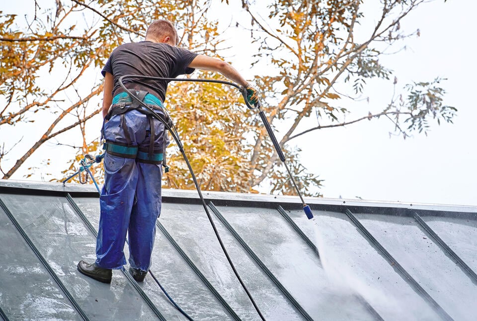 roof coating-man spraying standing seam metal roof