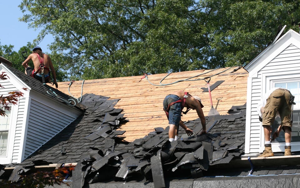 roof tear off-crew tearing off old roofing materials