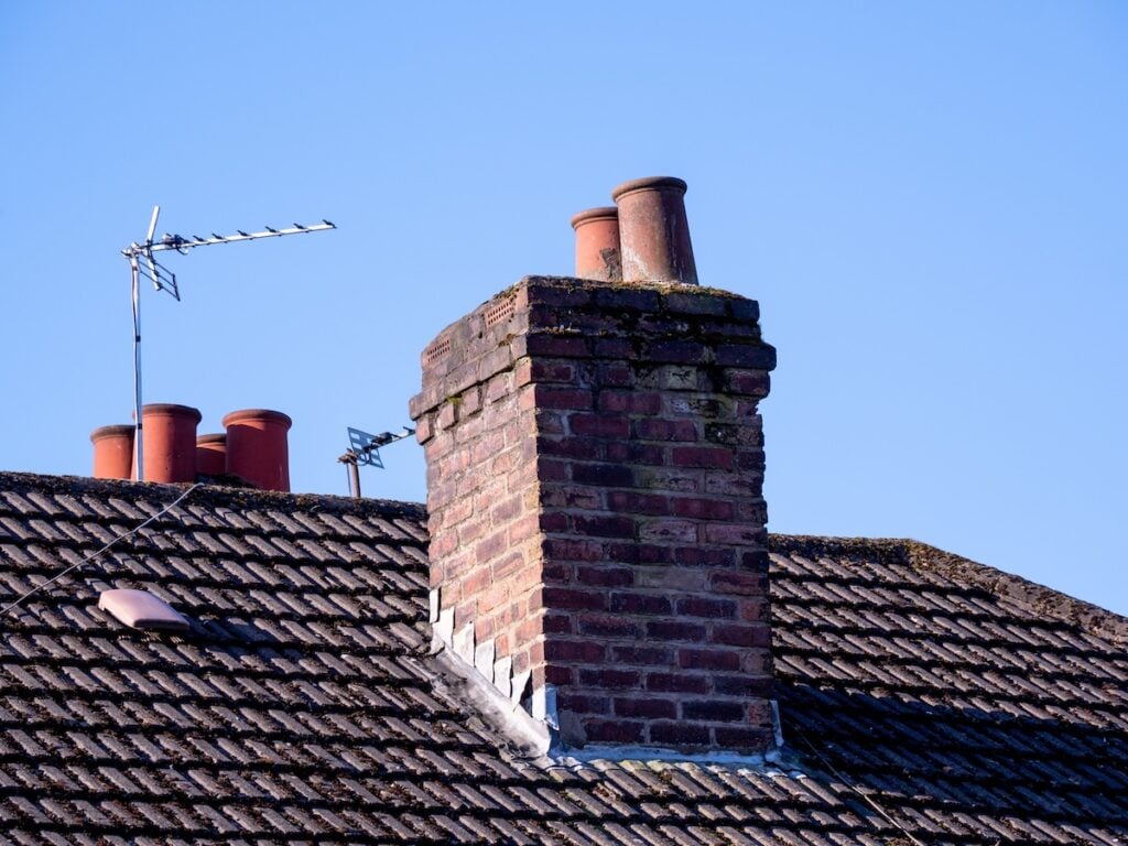 closeup of chimney pots on a tiled roofed house