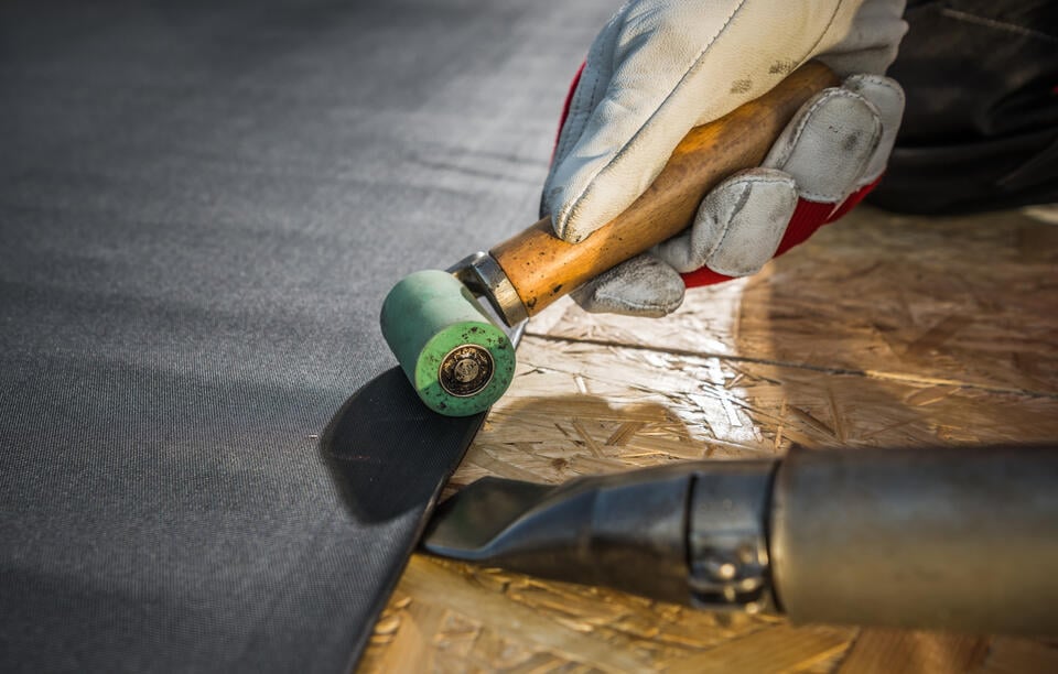 epdm roofing-close up of tech using tools to install panel of epdm roofing