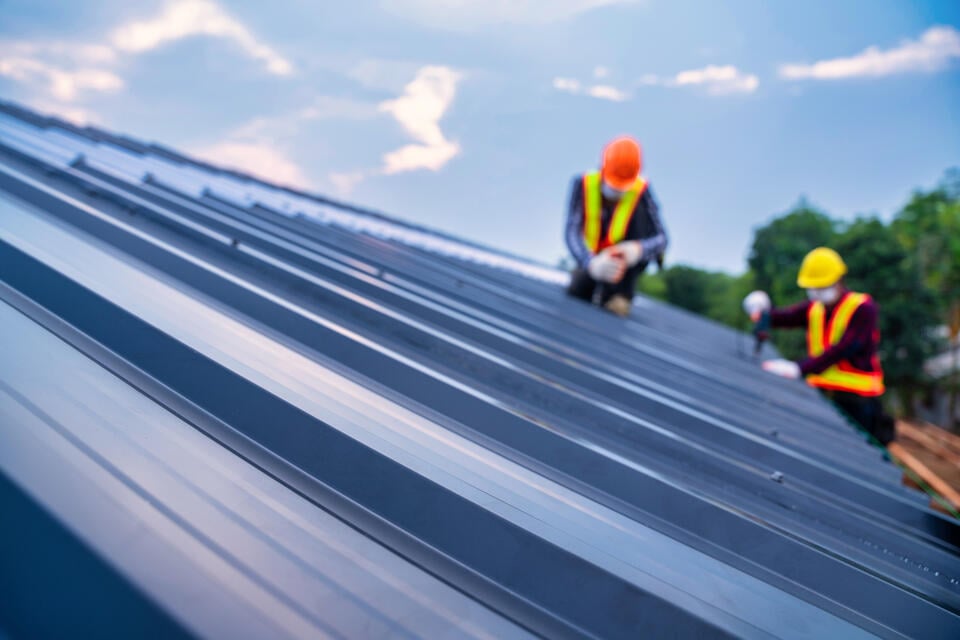 how much does a steel roof cost-two techs installing a metal roof
