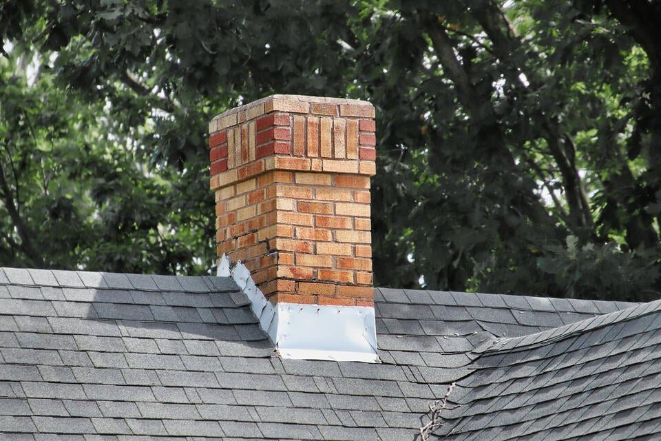roof flashing types-chimney flashing on gray shingle roof