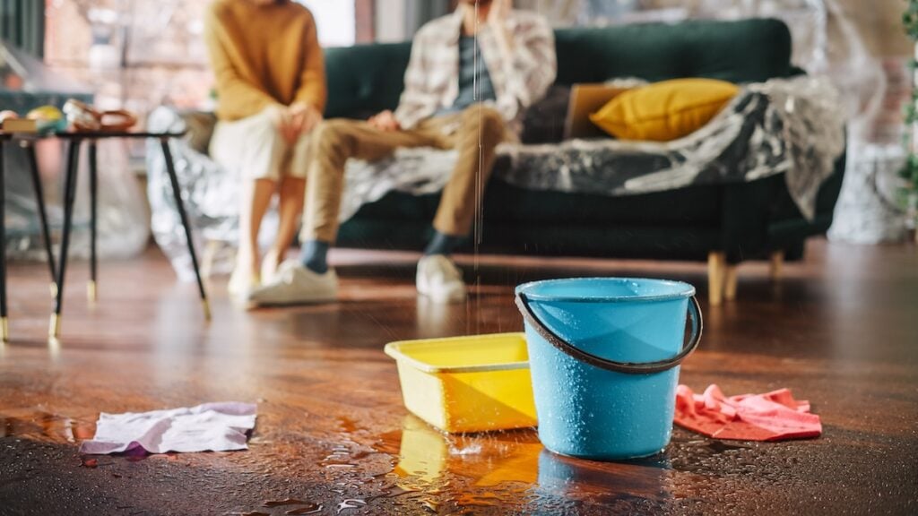 Rook leaking into living room of house and buckets catching water