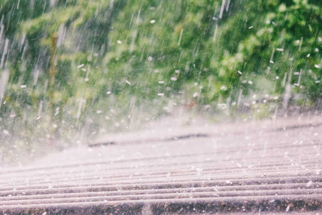 summer rain with hail falls on the roof 