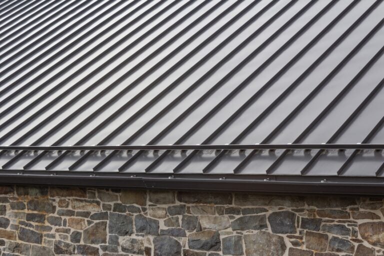 Standing seam modern metal roof over vintage stone building