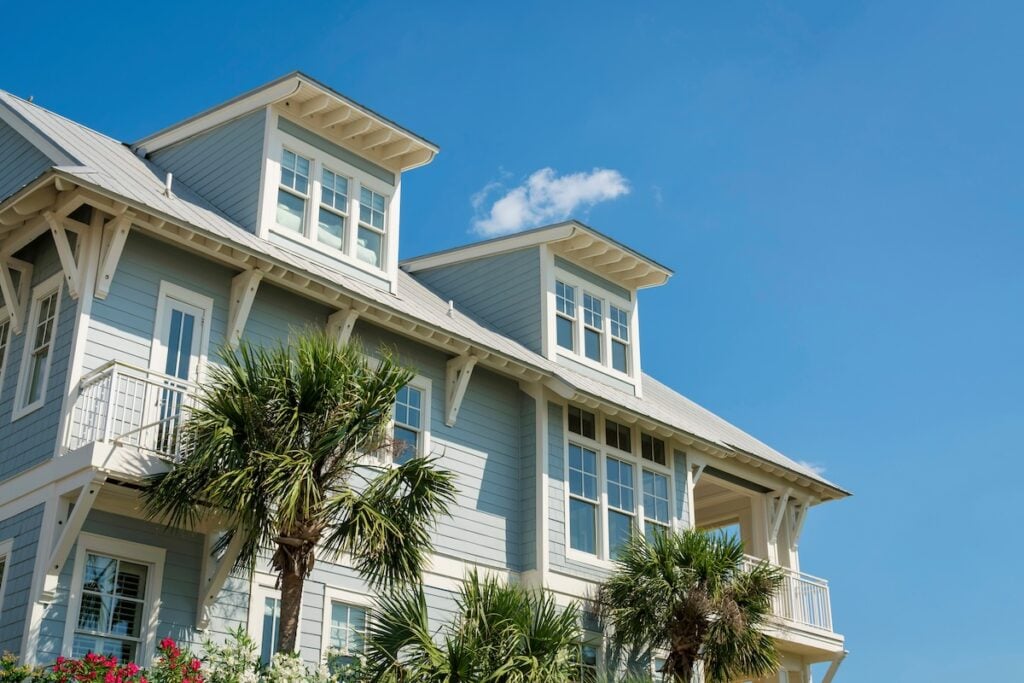 Low angle view of a house with light blue wood sidings and white trims in Florida. 